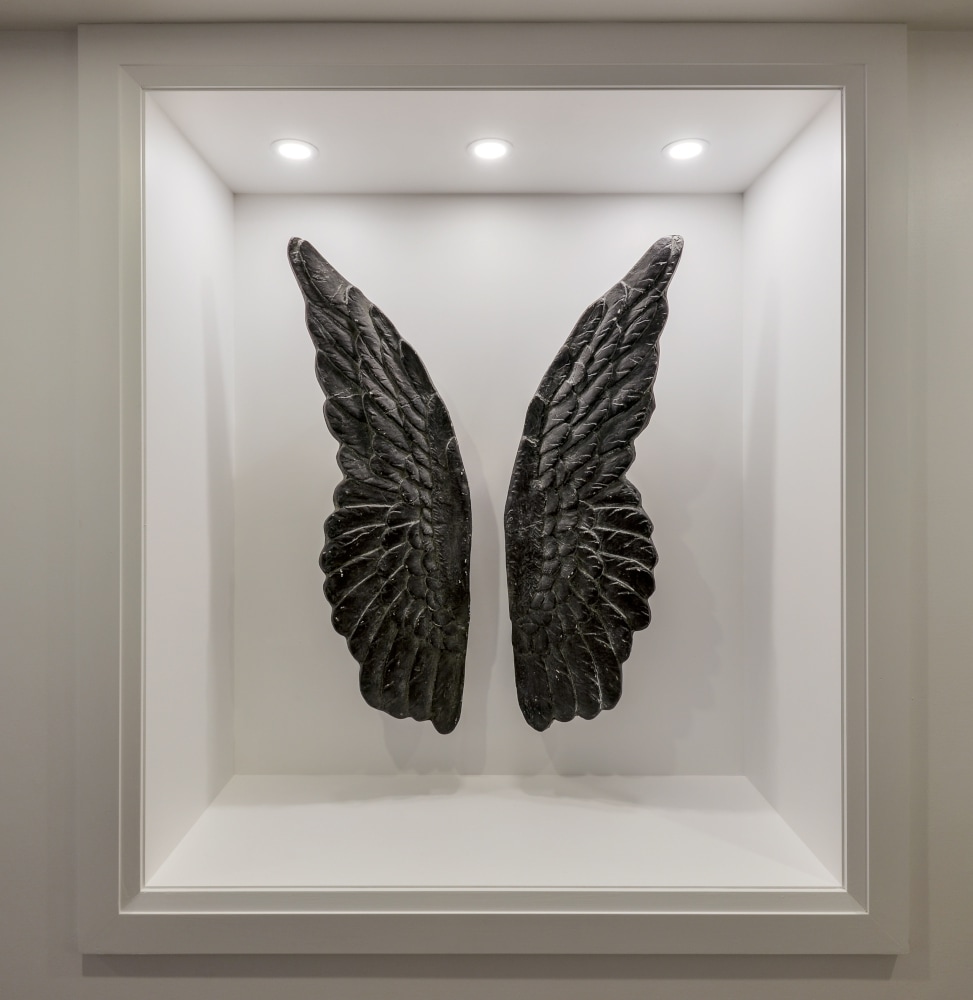 Hand carved wings in niche